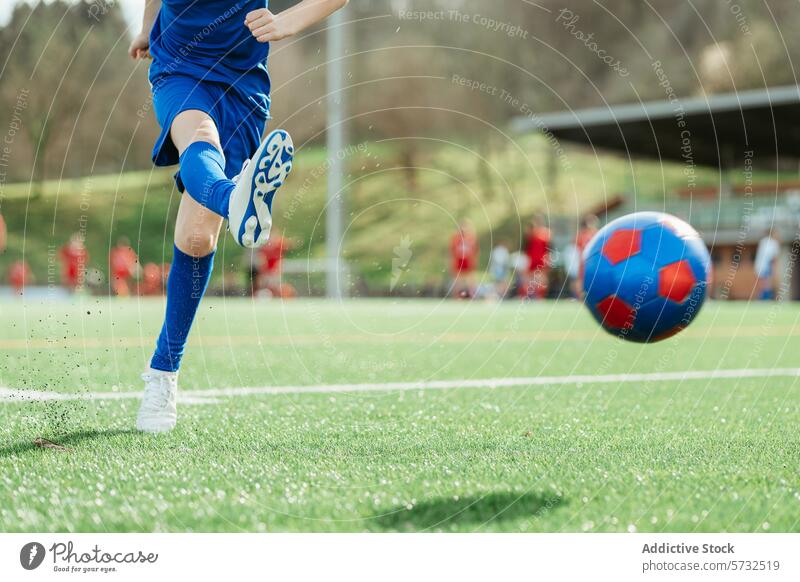 Fußballspieler, der an einem sonnigen Tag gegen den Ball tritt Spieler tretend Sonne blau rot grün Feld Sport im Freien Hintergrund Team Streichholz Konkurrenz