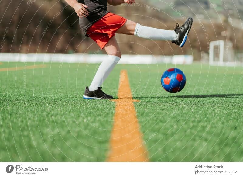 Fußballspieler dribbelt den Ball auf der Feldlinie Spieler dribbeln Linie Sport Bein grün Platz weiß Gras im Freien sportlich Sportbekleidung Training üben