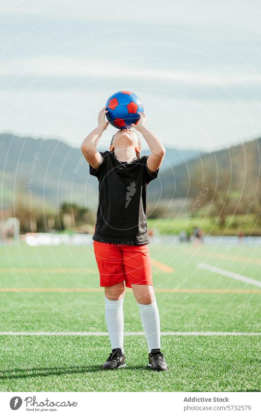 Junger Sportler übt Wurftechnik mit Ball Athlet Fußball Werfen Feld jung üben Technik Overhead Kopf bereit üppig (Wuchs) Gras im Freien tagsüber männlich Person