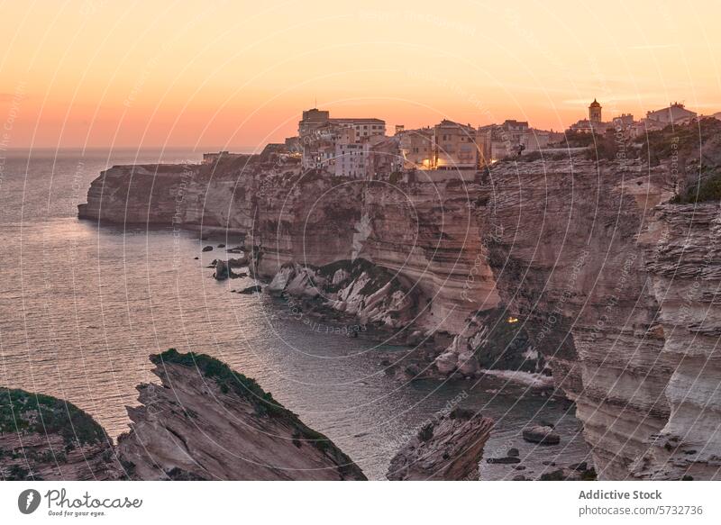 Die alte Klippenstadt Bonifacio in Korsika, Frankreich, leuchtet unter den warmen Farben des Sonnenuntergangs, mit Blick auf das ruhige MittelmeerBonifacio, Korsika, Frankreich, Sonnenuntergang, Klippen, Mittelmeer, Meer, Küste, Stadt, alt, leuchten, warm, Farben, ruhig, am Wasser, Gebäude, Architektur, Reisen, Tourismus, landschaftlich, Landschaft, natürliche Schönheit, Felsformation, Küste, historisch, Aussichtspunkt, Reiseziel, Abenddämmerung, Abend, ruhig, Natur, Kulturerbe, Klippen, Wasserlandschaft, Höhe, hoher Winkel, im Freien, europäisch, Insel, Urlaub, Besichtigung