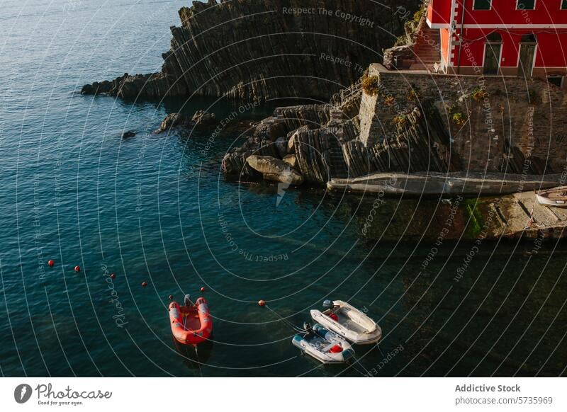 Ruhige Seeküste mit rotem Haus auf felsigen Klippen Ruhe rotes Haus felsige Klippen MEER verankerte Boote Wasser ruhig Küste Landschaft Natur Windstille blau