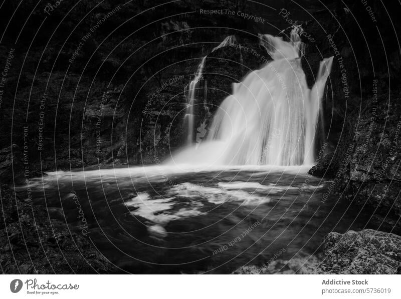 Eine Schwarz-Weiß-Darstellung des Rio Mundo-Wasserfalls mit seinen kräftigen Kaskaden, die einen starken Kontrast zu den umliegenden Felsen bilden. Spanien