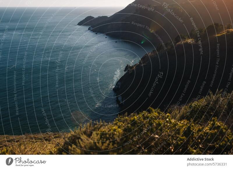 Die späte Nachmittagssonne wirft ein warmes Licht auf die zerklüfteten Klippen entlang der Pazifikküste, mit Blick auf den weiten Ozean Abenddämmerung pazifik