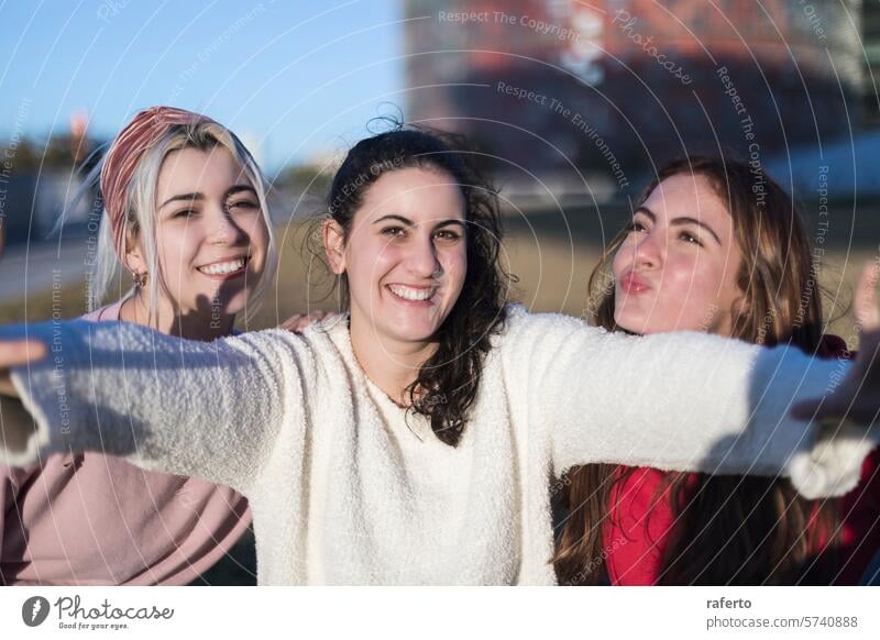 Fröhliche Freunde posieren mit ausgestreckten Armen im Sonnenlicht. Freundschaft Freude Frauen Lächeln im Freien spielerisch sonnig Glück lässig Jugend