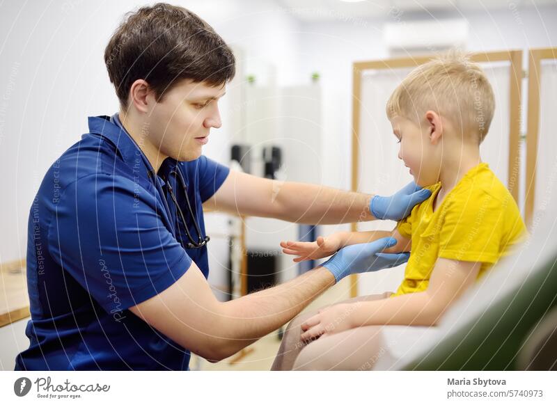 Ein niedlicher kleiner Junge und seine Mutter haben einen Termin bei einem Kinderarzt. Der Orthopäde untersucht die Gelenke des kleinen Patienten. Kinderärztin