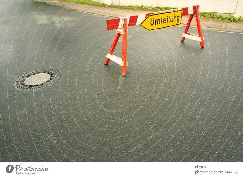 Umleitungswegweiser an einem alten hölzernen Sperrzaun auf einer Asphaltstraße Umleitungsschild Holzbake Schilder & Markierungen Barriere Bauzaun Straßenschild