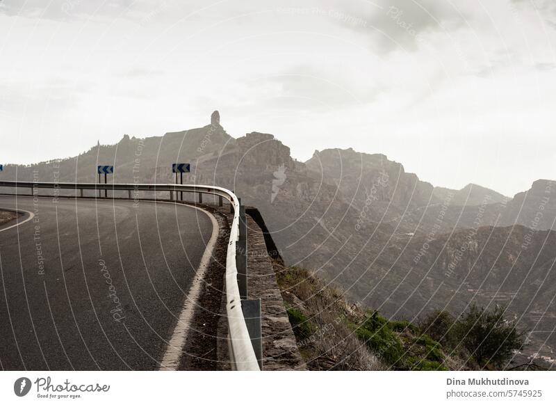 Kurvenreiche Straße in den Bergen mit Blick auf Fels- und Berggipfel bei bewölktem Wetter auf der Insel Gran Canaria Serpentinen Abenteuer Autoreise reisen