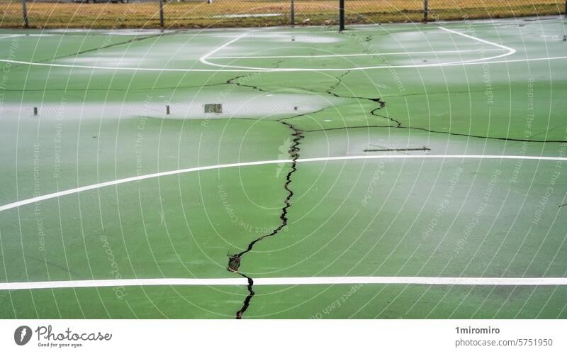 Leerer grüner Basketballplatz im Freien mit sichtbaren Rissen und weißen Linien Amerikaner Asphalt Korb Konkurrenz Gerichtsgrenzen rissige Oberfläche