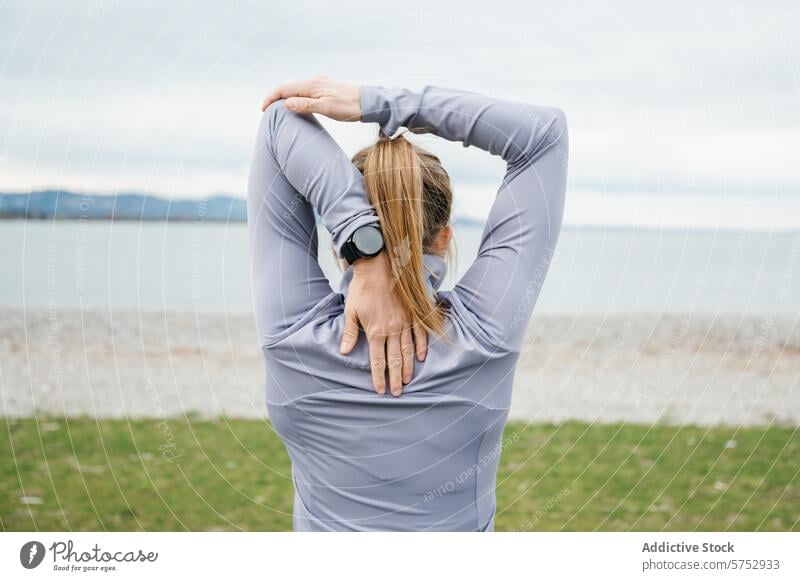 Junge Frau streckt Arme am Meer aus strecken Seeküste Athlet smartwatch Sportbekleidung Fitness Gesundheit Übung im Freien sportlich Training Wohlbefinden aktiv