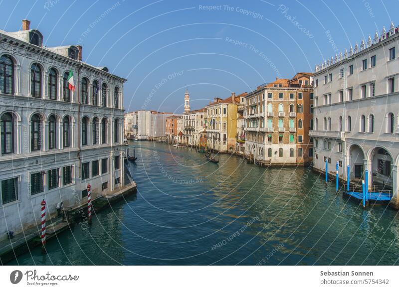 Blick von der Rialto-Brücke über den Canal Grande mit Gondelboot an einem sonnigen Wintertag vor typischen Gebäudefassaden, Venedig, Venetien, Italien Tourismus