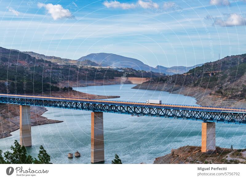 Lastwagen mit Kühlsattelauflieger auf einem Viadukt über einen Sumpf, Landschaft. Verkehr Brücke Regeln Granada Andalusia Stausee Sumpfgebiet Kühlschrank