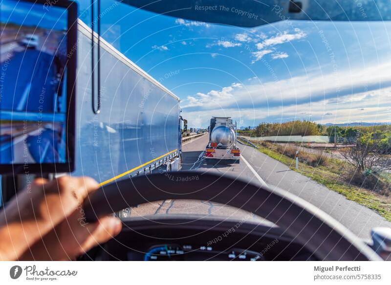 Lkw überholt zwei andere Lkw, gesehen aus der Kabine eines der überholten Lkw. Tanklastwagen mit ADR. Lastwagen Überholen Verkehr Laufwerk Straße im Inneren