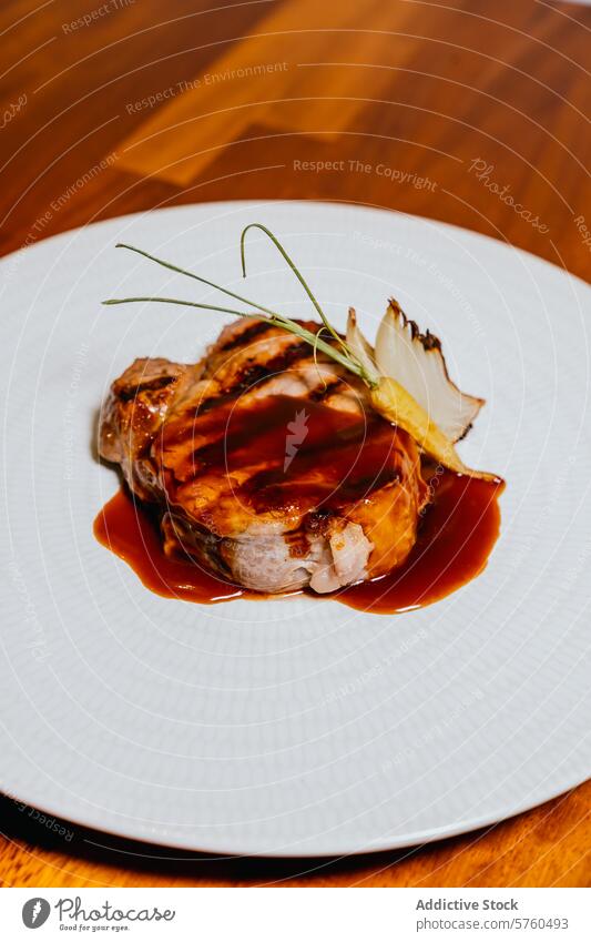 Ein saftiges Schweinesteak mit einer reichhaltigen Glasur, garniert mit einer Zwiebel und zartem Grün, serviert auf einem strukturierten weißen Teller vor einem Holzhintergrund