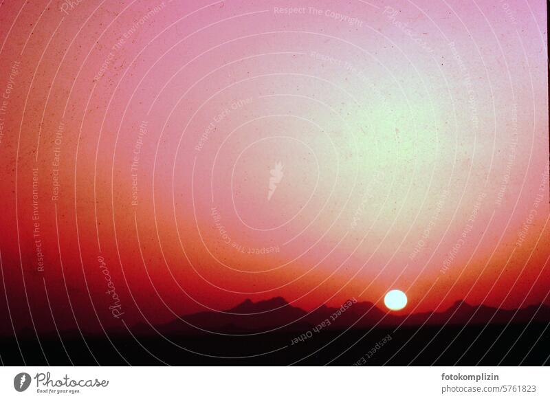 Sonne am roten Himmel über Berge sonnenuntergang verrotten Landschaft Natur Wüste Urelemente Panorama atmosphäre gebirge Abenddämmerung Sonnenlicht Wärme Licht