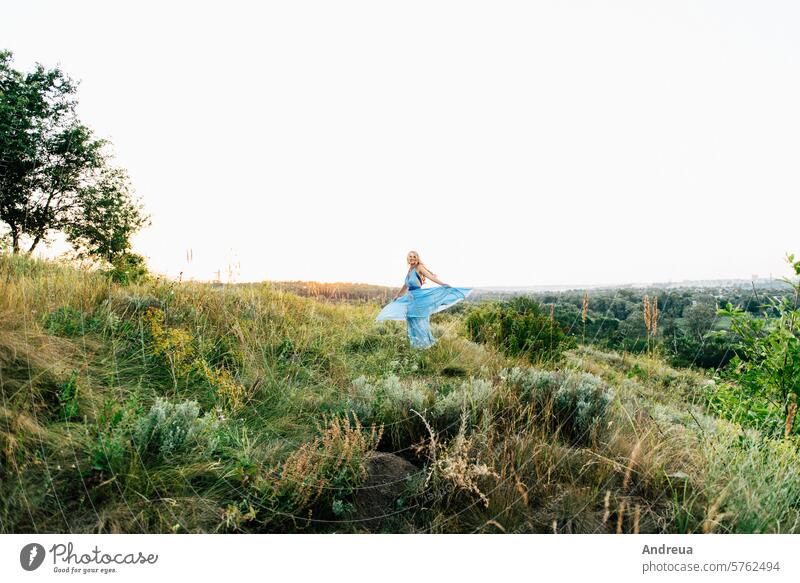 blonde Mädchen mit losen Haaren in einem hellblauen Kleid und ein Kerl im Licht des Sonnenuntergangs Air Schönheit Freund Braut Tag Engagement Abend Familie