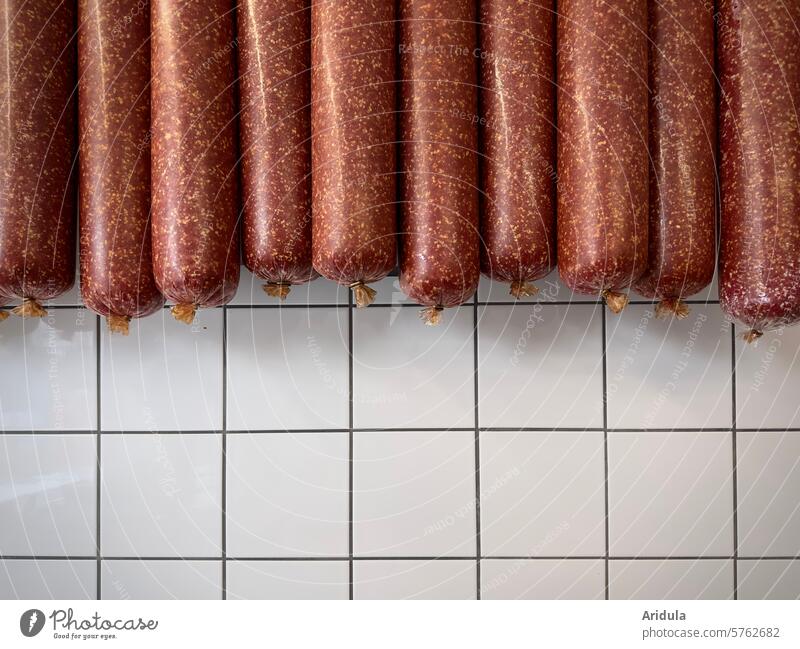 Mettwürste vor weißen Fliesen Wurst Fleisch Metzger Fleischer Wurstwaren Farbfoto Ernährung Metzgerei Handel Tier Schwein Essen Schlachtung Nutztier