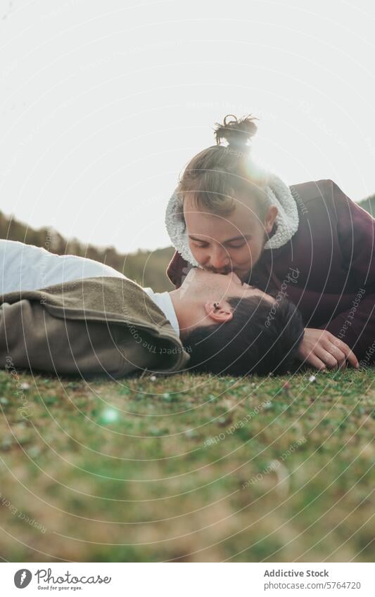 Im sanften Licht der Abenddämmerung küsst ein Mann die Stirn seiner Partnerin in einer friedlichen, grasbewachsenen Umgebung, ein Bild der Liebe und Zärtlichkeit