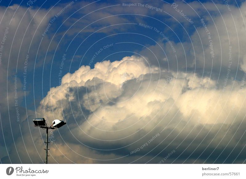 Frühlingswolken über dem Sportplatz Wolken Lampe Flutlicht Kunstlicht weiß grau Himmel wolkenstruktur Scheinwerfer blau