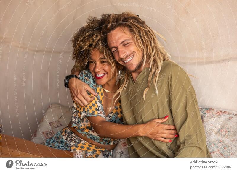 Freudige Umarmung eines heiteren Paares Rasta schwarze Frau Afro-Look multiethnisch Afrohaar Umarmen freudig Glück Rastalocken Lachen anhänglich warm