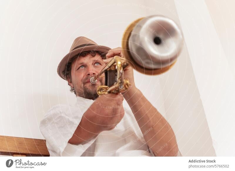 Einarmiger Musiker übt in der Halle Trompete einarmig üben heimwärts Hut Tatkraft Fokus Handwerk Instrument Messing Mann im Innenbereich Spielen Leistung