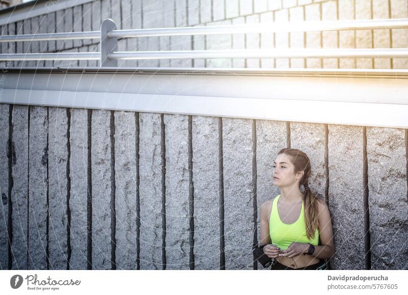 fröhliche Frau, die sich nach dem Sport, Laufen und Training ausruht. Fitness strecken aussruhen Übung jung Gesundheit hören Musik passen im Freien schön