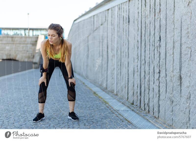 fröhliche Frau, die sich nach dem Sport, Laufen und Training ausruht. Fitness strecken aussruhen Übung jung Gesundheit hören Musik passen im Freien schön