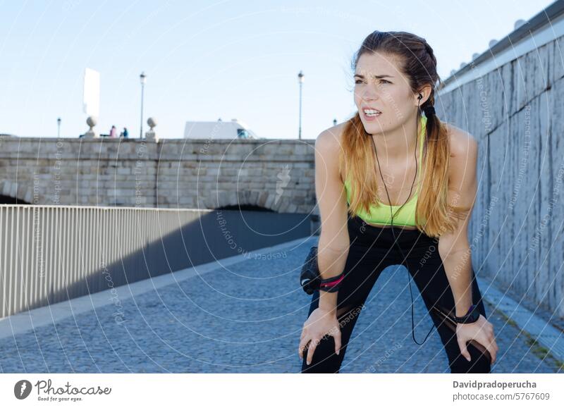 fröhliche Frau, die sich nach dem Sport, Laufen und Training ausruht. Fitness strecken aussruhen Übung jung Gesundheit hören Musik passen im Freien schön