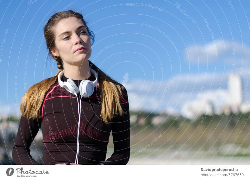 fröhliche Frau, die sich nach dem Sport, Laufen und Training ausruht. Fitness strecken aussruhen Übung jung Gesundheit hören Musik passen im Freien schön