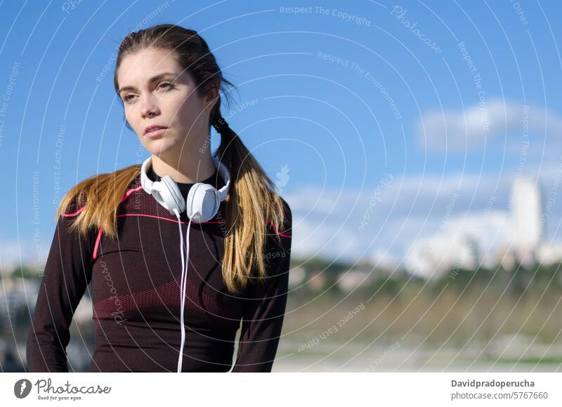 fröhliche Frau, die sich nach dem Sport, Laufen und Training ausruht. Fitness strecken aussruhen Übung jung Gesundheit hören Musik passen im Freien schön