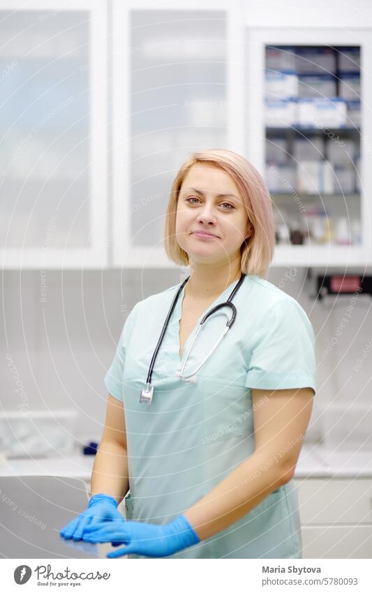 Vertikale Porträt der schönen Ärztin während der Ernennung von Patienten im Büro eine moderne Klinik. Geschickter Tierarzt ist am Arbeitsplatz im Tierkrankenhaus. Frau schaut in die Kamera