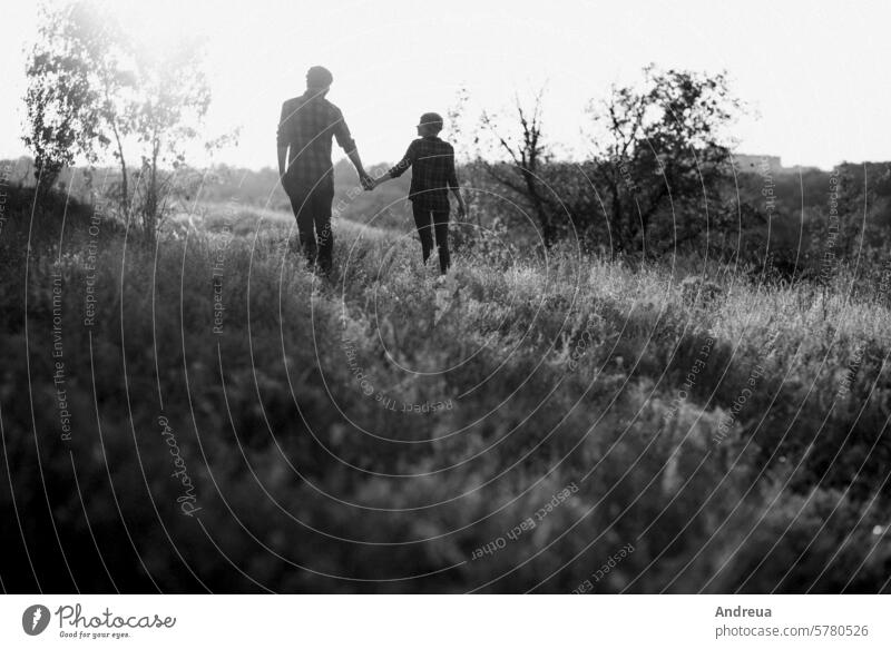 Fröhliche Kerl und Mädchen auf einem Spaziergang in hellen gestrickten Mützen Spaß Typ Gras Erde Natur Abend bei Sonnenuntergang orange rot Liebe Zusammensein