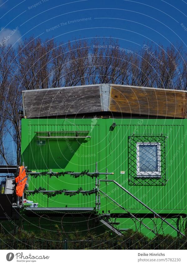 Die Warnweste an den Nagel gehängt: Feierabend im verschlossenen grünen Baucontainer. bauwesen Container sicherheitsweste Grün Außenaufnahme bauarbeiten