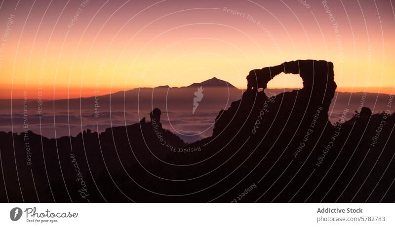 Sonnenuntergang durch den Bogen des Roque Nublo bei Teide Silhouette roque nublo Teide Berg Wolken warme Farbtöne Rahmung natürliches Fenster Wahrzeichen