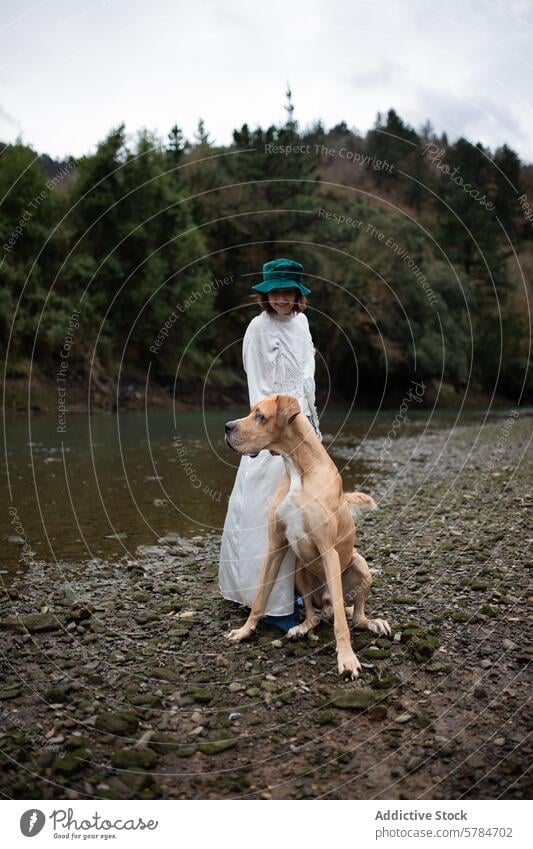 Gelassene Momente mit einer Frau und ihrem großen Hund am Fluss großer Hund Flussufer Gelassenheit Gesellschaft Natur friedlich Bäume Wasser im Freien Freizeit