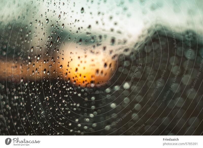 Untergehende Sonne durch die verregnete Fensterscheibe Sonnenuntergang Regen und Sonnenschein Wolken Himmel Abend Unschärfe Dämmerung Licht Wetter Natur