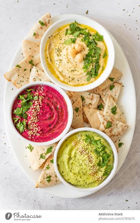 Drei Hummus-Sorten mit frischen Zutaten Trio klassisch Rübe Avocado Snack Amuse-Gueule Dip Pita Brot Kichererbsen Kalk Zitrone Knoblauch Cumin Salz Tahini