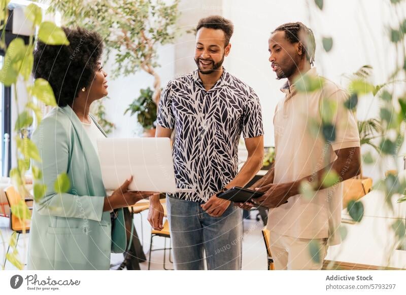 Ein vielseitiges Team arbeitet in einem modernen Coworking Space zusammen vielfältig Zusammenarbeit professionell Besprechung arbeiten hell mit Pflanzen gefüllt