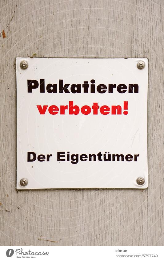 quadratisches Schild - Plakatieren verboten!  Der Eigentümer - an einer grauen Wand Schilder & Markierungen keine Plakate Hinweisschild Verbotsschild