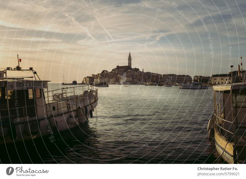 Sommer. Boote in einer Bucht vor einer idyllischen Stadt im Sommer während des Sonnenuntergangs. Schönes Wetter Schönheit Abenddämmerung Dämmerung Wind