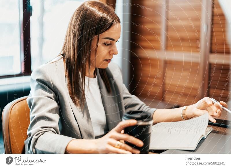 Frau bei der Arbeit in einem Büro mit einer Thermoskanne mit Kaffee Geschäftsfrau Business arbeiten Laptop im Innenbereich Unternehmer professionell Manager