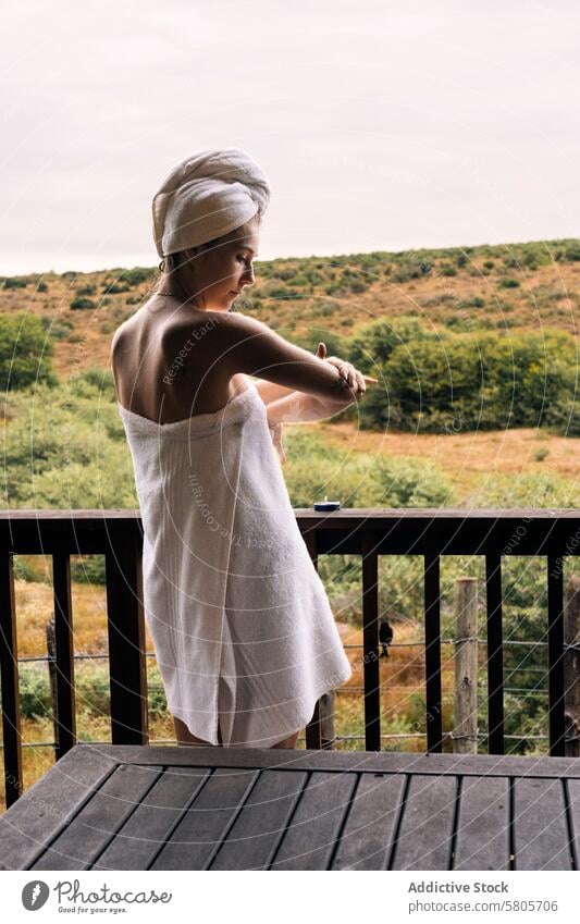 Frau entspannt auf Balkon mit Blick auf die Natur Handtuch Erholung Ruhe hölzern Wegsehen nachdenklich friedlich Naturlandschaft im Freien Gelassenheit Freizeit