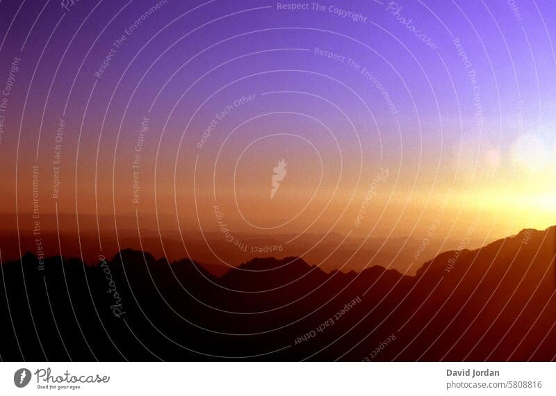 lila Himmel über einen orange-roten Sonnentuntergang von einem Berg aus gesehen Sonnenuntergang Sonnenuntergangshimmel lila himmel lila orange roter Himmel