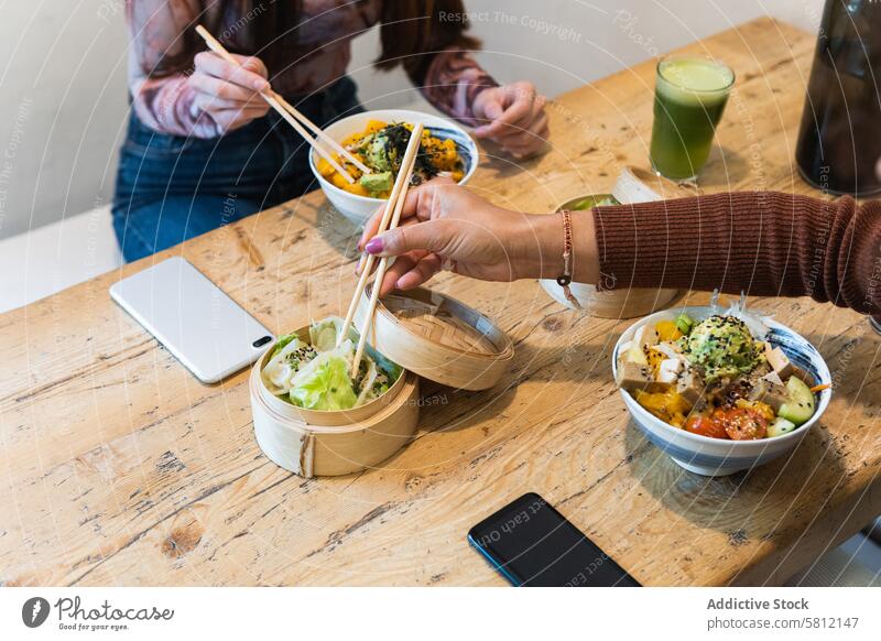 Crop-Frau isst Poke-Gericht im Restaurant stoßen Speise essen dienen geschmackvoll Tradition hawaiianisches Essen lecker Mahlzeit Essstäbchen Portion