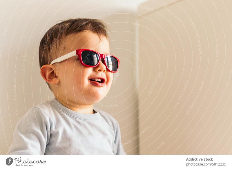 lustiges Baby mit Sonnenbrille sitzt zu Hause niedlich heimwärts Glück Kind Spaß jung Kaukasier Kleinkind wenig Sitzen Hintergrund Porträt Mädchen Menschen Mode