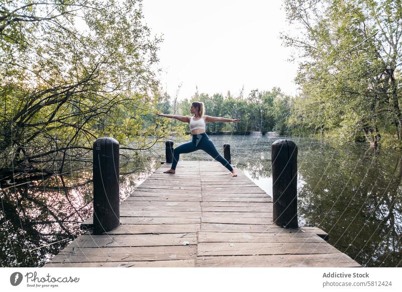 Frau in Sportkleidung macht Yoga in der Natur in der Nähe eines Sees Gesundheit Übung Lifestyle Fitness Körper Training Kaukasier Sportbekleidung Pilates jung