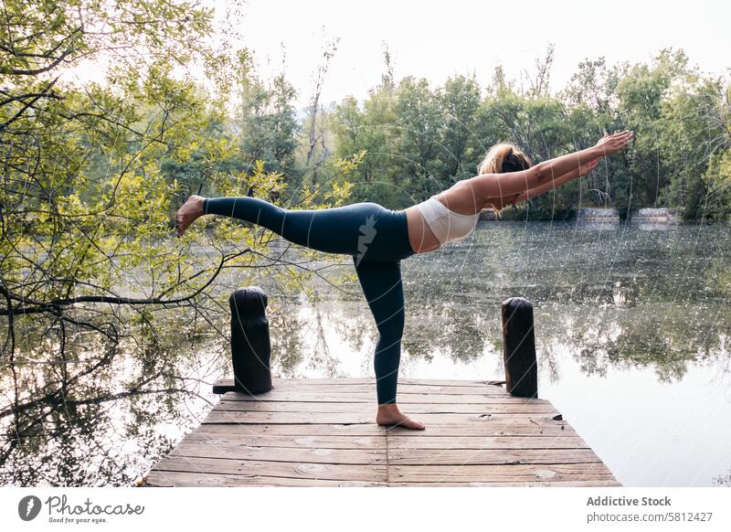 Frau in Sportkleidung macht Yoga in der Natur in der Nähe eines Sees Gesundheit Übung Lifestyle Fitness Körper Training Kaukasier Sportbekleidung Pilates jung