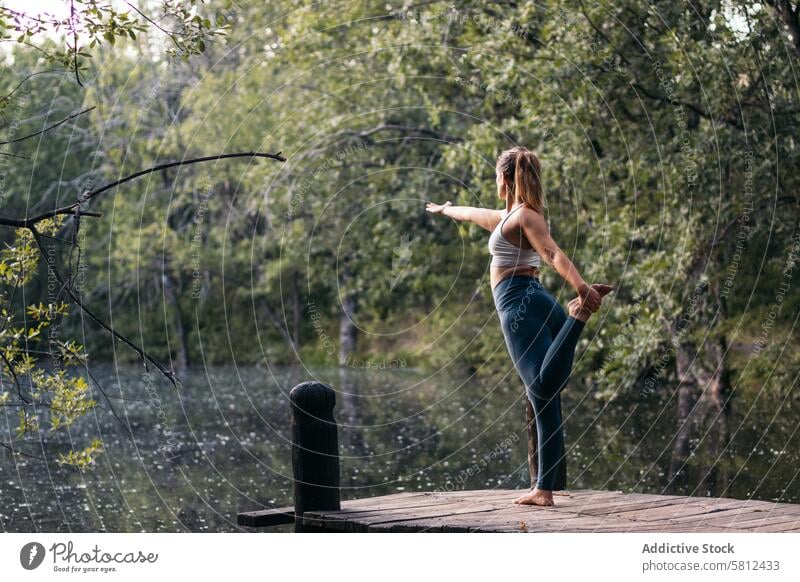 Frau in Sportkleidung macht Yoga im Freien in der Nähe eines Sees Gesundheit Übung Lifestyle Fitness Körper Training Kaukasier Sportbekleidung Pilates jung