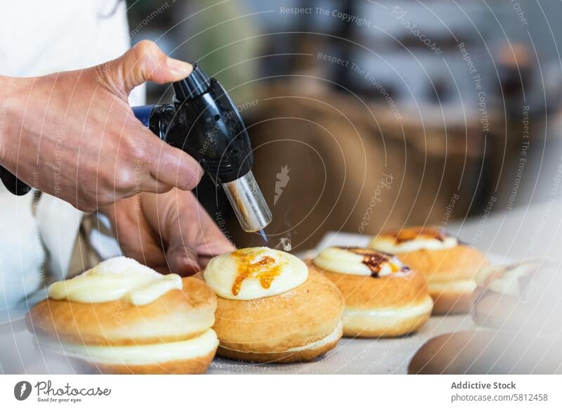 Crop Koch brennt Sahne auf Dessert mit Gasbrenner in Bäckerei berliner Fackel Brenner Zucker Kruste backen Veganer Küche vorbereiten süß Gebäck Flamme