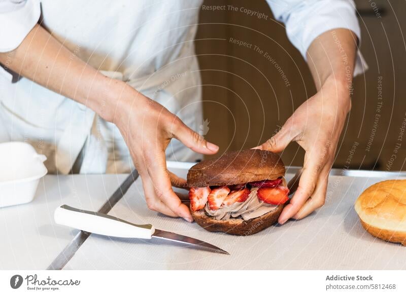 Crop Cook mit Biskuit Bäcker Schwamm Kuchen Bäckerei Koch vorbereiten Dessert Veganer süß Erdbeeren gepeitscht Sahne frisch Gebäck kulinarisch Lebensmittel