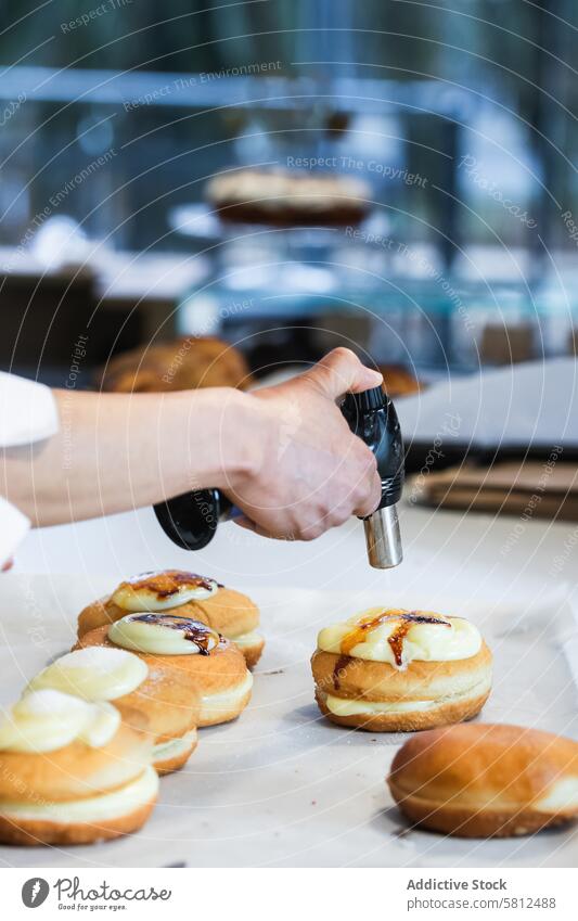 Crop Koch brennt Sahne auf Dessert mit Gasbrenner in Bäckerei berliner Fackel Brenner Zucker Kruste backen Veganer Küche vorbereiten süß Gebäck Flamme